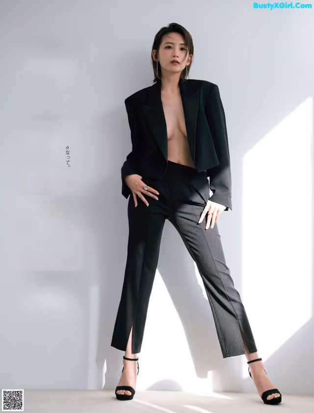A woman in a black suit posing for a magazine.