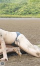 A woman in a bikini laying on the beach.