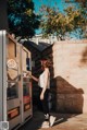 A woman standing in front of a vending machine.