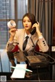 A woman sitting at a desk talking on a phone.