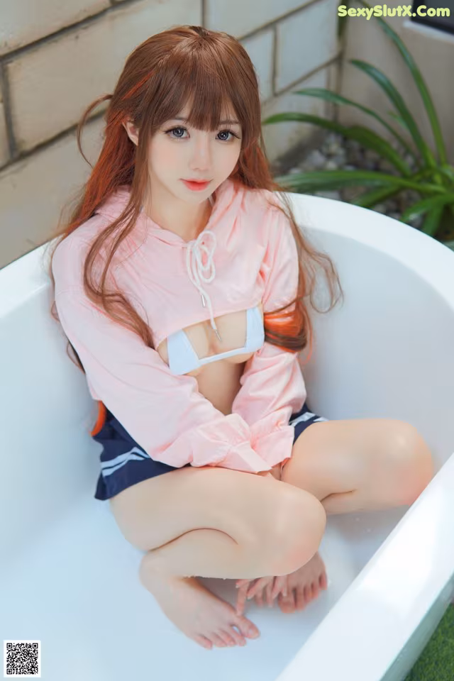 A woman sitting in a bathtub with her legs crossed.