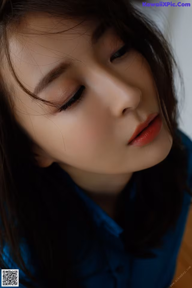 A close up of a woman's face with long dark hair.