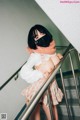 A woman wearing a face mask standing on a stairwell.