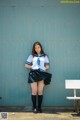 A woman in a school uniform posing for a picture.