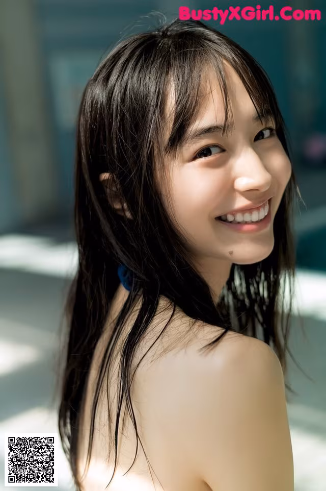 A young woman with long black hair smiling at the camera.
