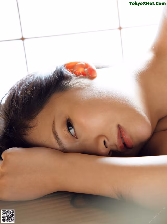 A woman laying on a bed with her eyes closed.