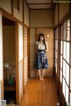 A woman standing in a room with wooden floors.