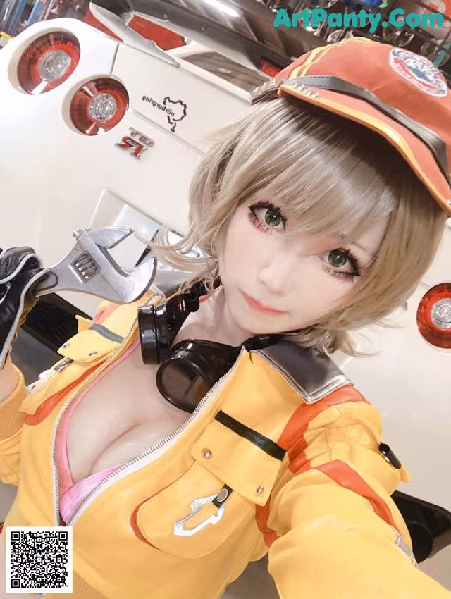 A woman in a yellow jacket and hat holding a wrench.