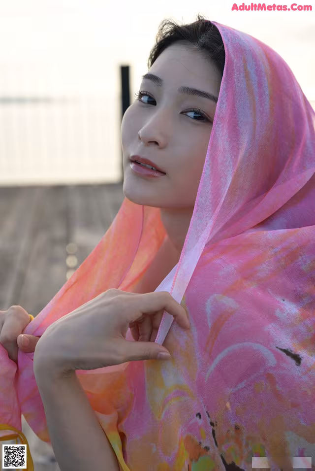 A woman wearing a pink and yellow scarf.