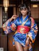 A woman in a blue and orange kimono posing for a picture.