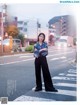 A woman standing in the middle of a street with her arms crossed.