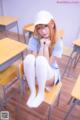 A woman sitting on a chair in a classroom.