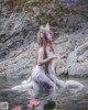 A woman in a white dress is sitting in the water.